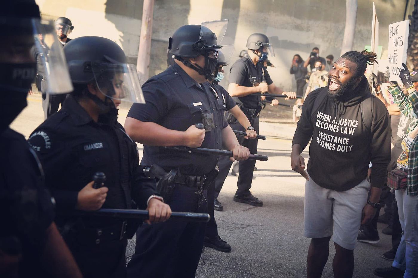 Lawrence standing face to face with a police line at a 2020 protest in Los Angeles
