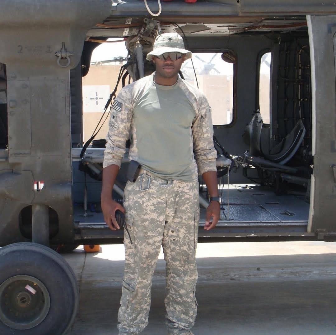 Lawrence in uniform in front of a Black Hawk helicopter