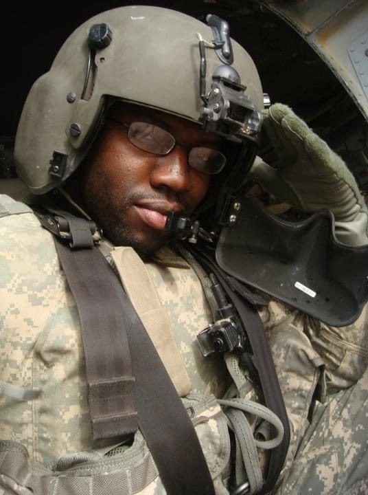 Lawrence in a flight helmet aboard a helicopter