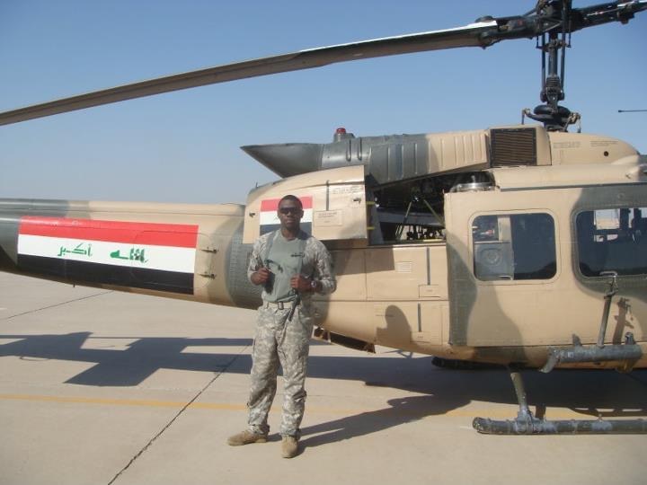 Lawrence beside an Iraqi Air Force helicopter on the flight line
